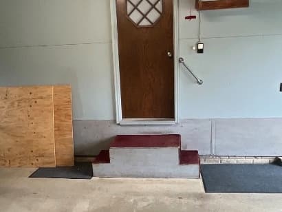 Existing hazardous garage steps with uneven heights and no railing